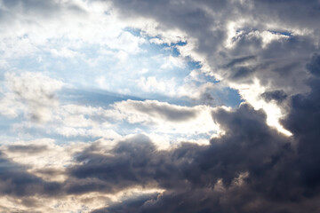 Obraz premium Rays of the sun through thunderclouds. Blue sky. Before a storm or thunderstorm.