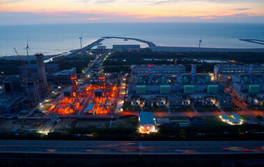 Aerial view of Tatan Power Plant in an industrial estate and wind turbines along the coast with...