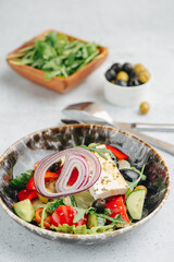 Delicious greek salad on a plate. Vegetables, oil and cottage cheese.