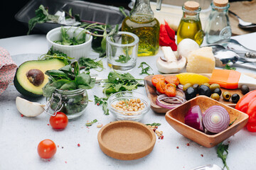 Olives, onion, greens, oil, pine nuts. A table full with ingredients for salad.
