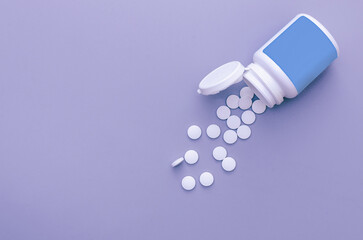 White pills, spilled from a jar.