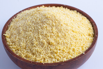 Nigerian yellow and white garri in a wooden bowl.