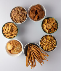 A selection of Nigerian snacks - kokoro, gurudi, chinchin, groundnut, coconut candy, kokoro, plantain chips and kulikuli.