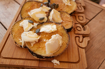 Fried aubergines with goat cheese and pumpkin seeds