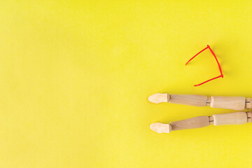 wooden man sunbathing on yellow background, copy space