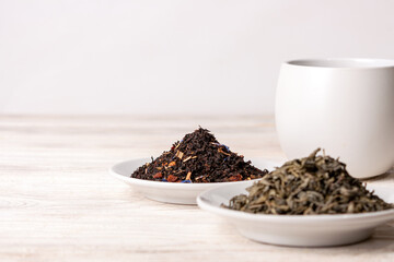 varieties of black and green tea on a white background, selective focus, copy space