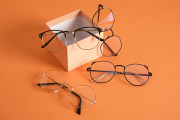 eye glasses on gift box orange background copy space