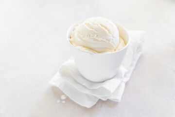 Vanilla ice cream in white cup, marble background