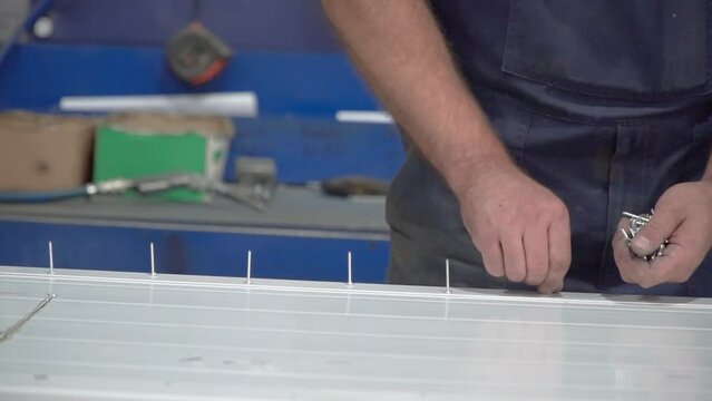 worker installing rivets. a worker installs aluminum rivets with a certain pitch.