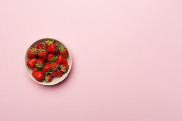 Bowl with fresh strawberries on color background, top view