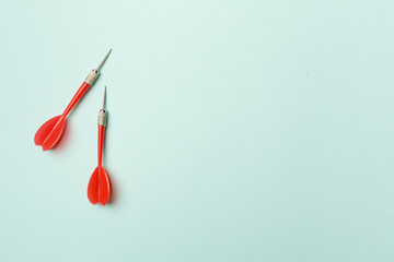 Red darts on color background, top view