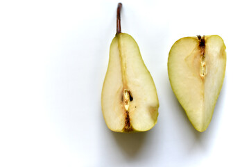 Sliced green pear in half on a white background