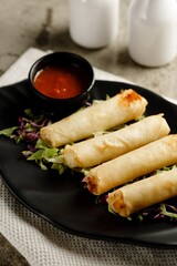 Vegetable Spring Roll with chili sauce served in a dish isolated on grey background side view fast food