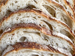 Slices of  fresh bread background. Freshly baked and sliced San Francisco sourdough loaf bread Food background and texture lunch time