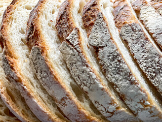 Slices of  fresh bread background. Freshly baked and sliced San Francisco sourdough loaf bread Food background and texture lunch time