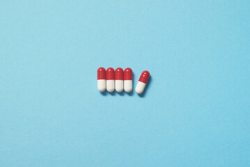 Pharmaceutical pills over blue backdrop.