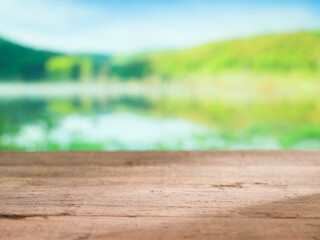 Naklejka na ściany i meble Empty wood table and lake background. ( selective focus ) Blurry view. Suitable for your product display for graphic design