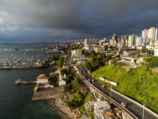Fototapeta premium Storm clouds arriving as the setting sun illuminates the city of Salvador