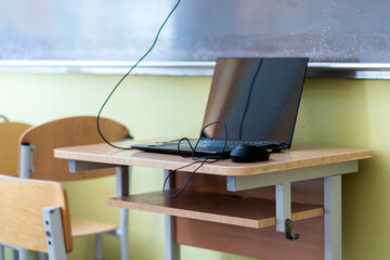 Computer on wooden table in classroom