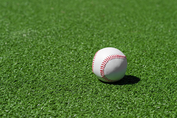 Baseball ball on green grass field. Sport theme background. Horizontal sport theme poster, greeting cards, headers, website and app