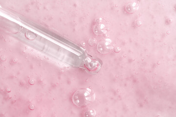 Closeup of pipette with serum, oil, gel with lilac flowers on white background. Skincare, natural...