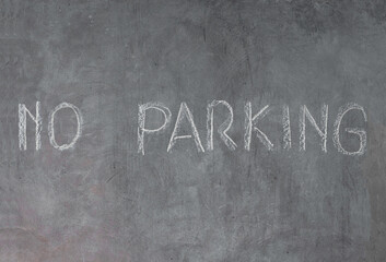 Fototapeta premium Cement wall with no parking sign written in chalk