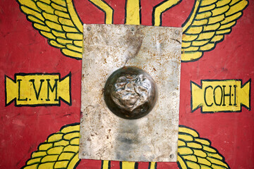 Red vintage shield of an ancient Roman warrior. Reconstruction of military events during the war of the Roman Empire