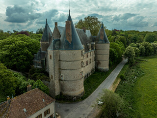 Aerial  view of Jaligny-sur-Besbre Renaissance castle with two massive round towers, pointy roofs with chimneys in 	
Auvergne-Rhône-Alpes in France