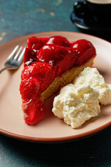 Close up view of piece of strawberry cake on plate, with whipped cream
