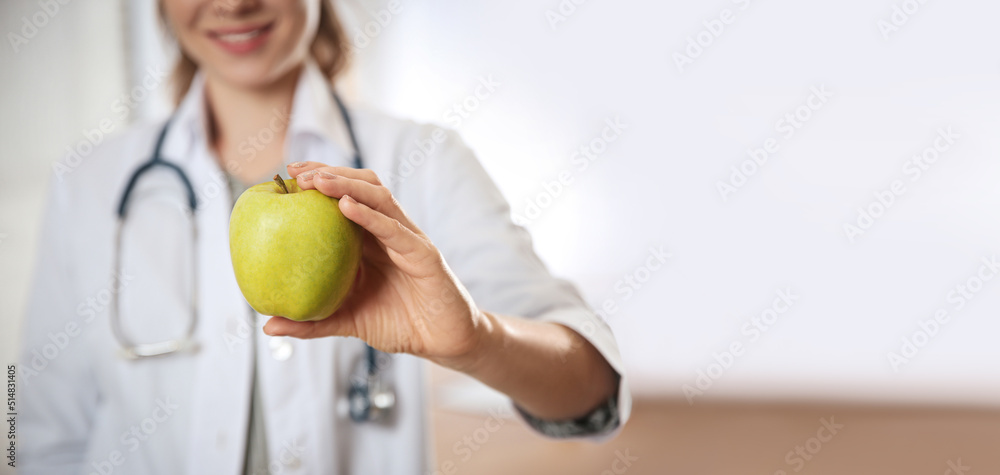 Poster Nutritionist with fresh apple in her office, closeup view with space for text. Banner design