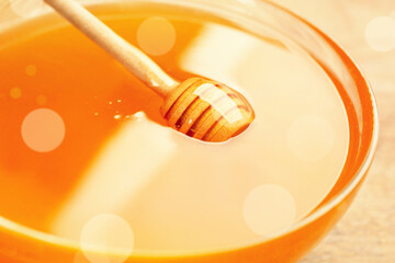 Tasty honey in glass bowl on table, closeup