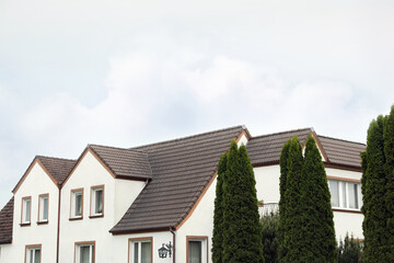 Fototapeta na wymiar Beautiful house with brown roof against blue sky