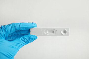 Doctor holding disposable express test for hepatitis on white background, closeup