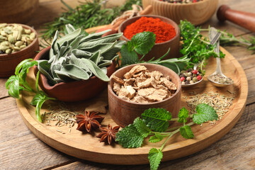 Different herbs and spices on wooden table, closeup
