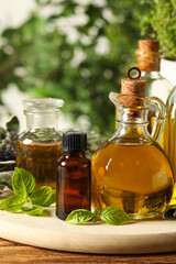 Different fresh herbs with oils on wooden table