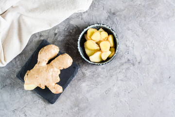 Sliced fresh raw ginger root in a bowl on the table. Alternative medicine. Top view