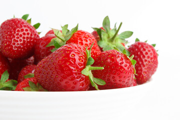 Red ripe strawberry in the white bowl