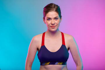 Fototapeta na wymiar Sporty woman in fitness bra. Female portrait isolated on neon multicolor background.