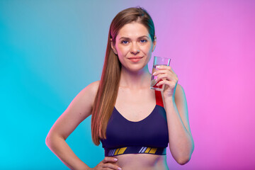 Smiling girl holding water glass. Female fitness portrait isolated on neon color background.