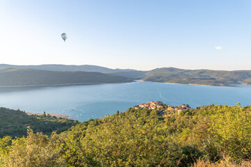 Panorama sur le lac de Sainte Croix dans les gorges du Verdon avec le survol par une montgolfière bleue