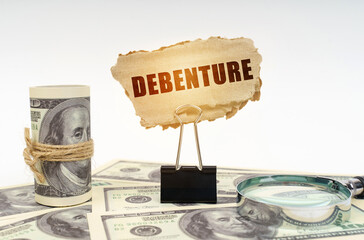Among the dollars lies a magnifying glass and there is a clip and a cardboard sign with the...