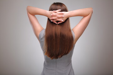 Isolated business woman back view portrait with folded hands on neck, business person, teacher or adult student with long hair.
