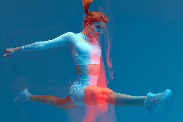 Sports jump. Sportive fitness girl gymnast jumping doing splits in air. Long exposure, colorful...