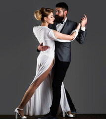 Beautiful couple in love dancing passionate dance. Professional dancers in elegant suit and dress.