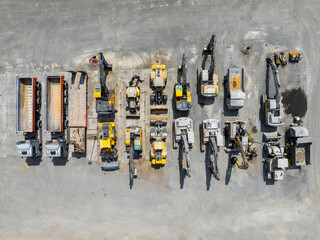 Parked heavy machinery and trucks. Industrial place, aerial view. 