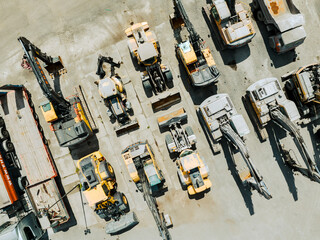 Parked heavy machinery and trucks. Industrial place, aerial view. 