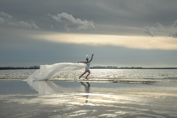 A fabulous girl in a long transparent dress fluttering in the wind and a high headdress on the...