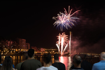 people watching the fireworks of the bonfires of San Juan in Alicante from the Melia hotel, near the postiguet beach.