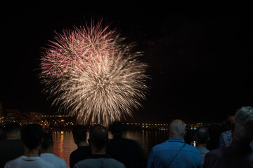 people watching the fireworks of the bonfires of San Juan in Alicante from the Melia hotel, near...