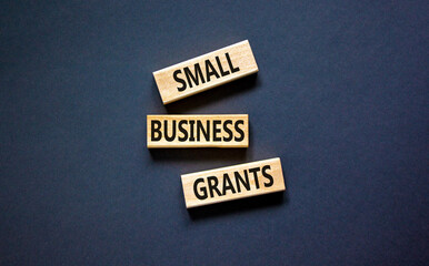 Small business grants symbol. Concept words Small business grants on wooden blocks on a beautiful black table black background. Business, finacial and small business grants concept.